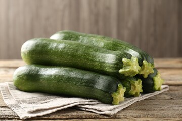 Fresh ripe zucchinis on wooden table, closeup