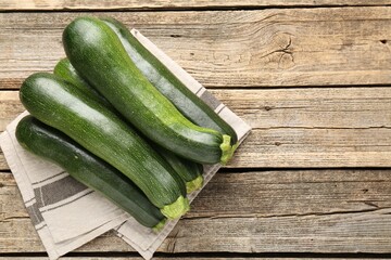 Fresh ripe zucchinis on wooden table, top view. Space for text