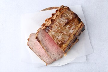 Delicious baked beef meat on light table, top view