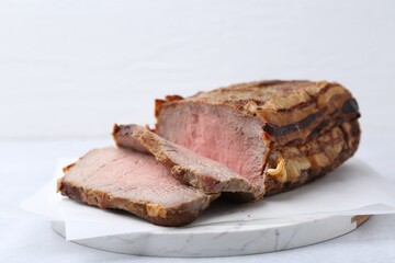 Delicious baked beef meat on light table, closeup
