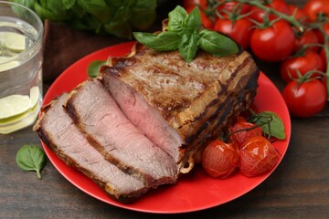 Delicious baked beef meat, tomatoes, basil and refreshing drink on wooden table, closeup