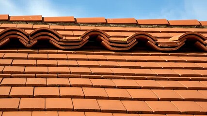 Red Tile Roof Close-Up - A detailed close-up shot of a house roof covered in red clay tiles. The video showcases the texture and pattern of the tiles, with a focus on the ridge capping. - Powered by Adobe