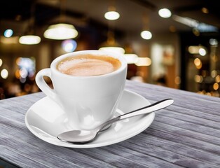 Tasty hot coffee in white cup on table