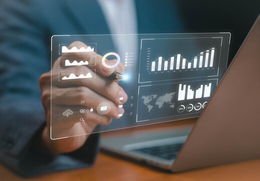 Businessman using futuristic digital dashboard with data analytics, charts, graphs, and statistics on laptop screen, concept of big data, financial analysis, business intelligence, and technology.