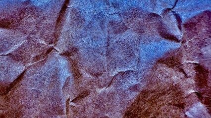 abstract crumpled violet and blue metallic fiber surface with folds and shadows ideal for textured...