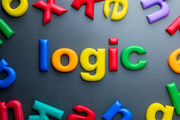 Colorful foam letters spelling the word “logic” on dark background, educational or conceptual...