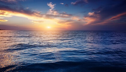 Obraz premium a calm ocean with a beautiful sunset in the background