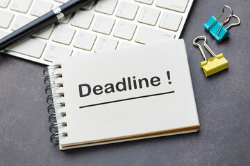 Deadline reminder on notebook with keyboard and office tools
