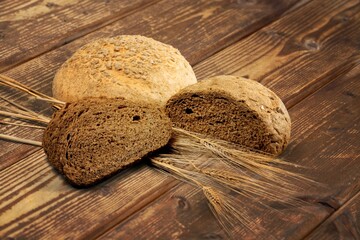 Whole wheat tasty fresh bread sliced on wooden board
