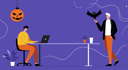 Office colleagues celebrate Halloween. One works on a laptop while the other holds a bat decoration, blending holiday spirit with a modern workspace.