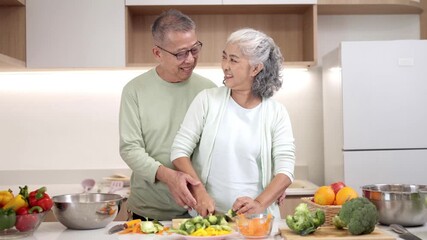 Asian older couple cooking fresh vegetables modern kitchen preparing healthy food sharing happy moment together home - Powered by Adobe