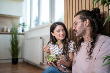 Young couple enjoying a healthy salad at home