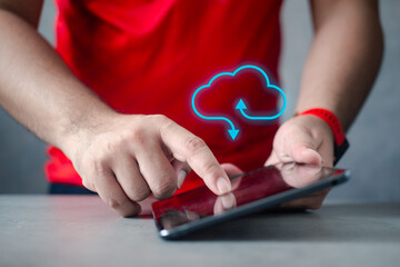 Young man holding a tablet with virtual cloud computing to transfer data information and upload and...