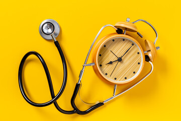 Stethoscope and vintage alarm clock, top view. Time for medical checkup