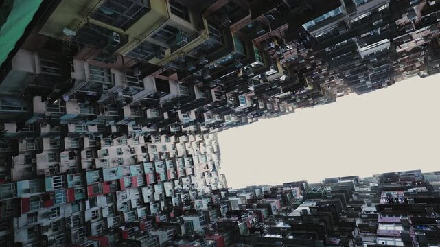 Rotating upward view of crowded residential Monster Building complex. Symbol of overpopulation, social inequality, urban density and dramatic contrast of city life.