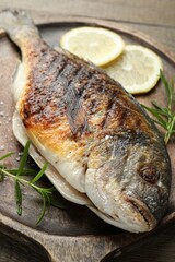 Tasty roasted dorado fish and spices on table, closeup. Homemade seafood dish