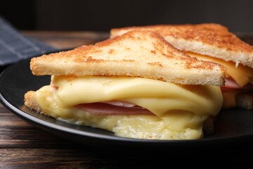 Delicious sandwiches with melted cheese and ham on wooden table, closeup
