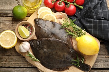 Fresh flounder fish, spices and products on wooden table, flat lay. Raw seafood