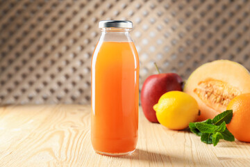 Tasty juice in glass bottle, fresh fruits and mint on wooden table indoors, closeup