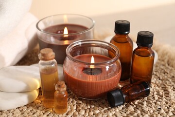 Spa composition with burning candles on table against beige background, closeup
