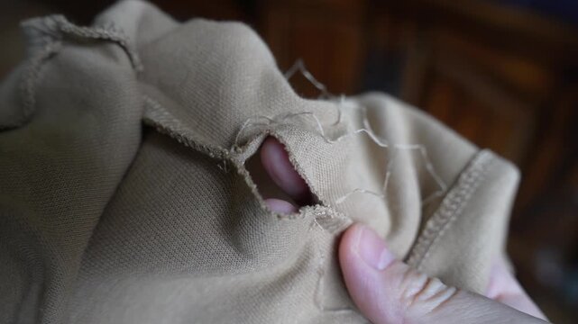 Close-Up of T-Shirt Falling Apart at Seams &ndash; Stitches Unraveling and Fabric Damage
