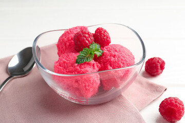 Delicious raspberry sorbet with mint in bowl, spoon and fresh berries on white wooden table, closeup