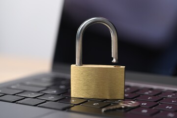Cyber safety. Metal padlock on laptop, closeup