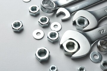 Metal wrenches and nuts on white background, closeup