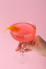 Woman with martini cocktail on pink background, closeup