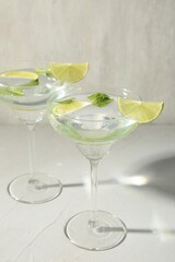 Martini cocktails with lime and mint on grey table, closeup
