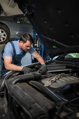 Mechanic repairing car engine in auto repair shop
