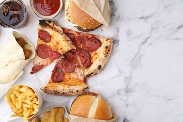 Different delicious fast food and soda drink on white marble table, flat lay
