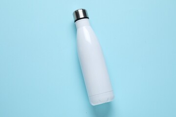 Water bottle on light blue background, top view