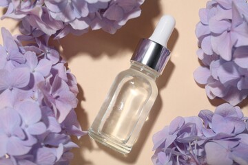 Cosmetic product and flowers on beige background, flat lay. Mockup for design