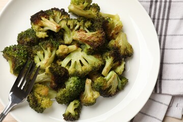 Tasty fried broccoli and fork on table, top view
