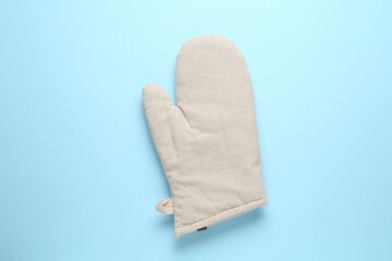 One oven glove on light blue background, top view