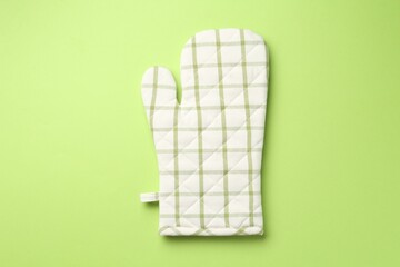 One oven glove on green background, top view