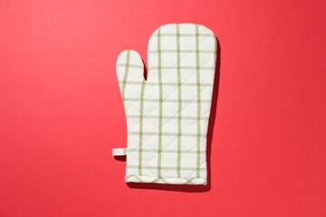 One oven glove on red background, top view