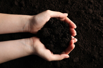 Woman with pile of fresh soil, top view