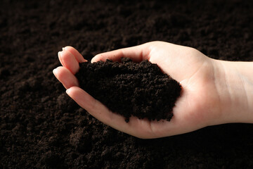 Woman with pile of fresh soil, closeup