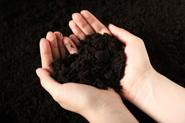 Woman with pile of fresh soil, closeup