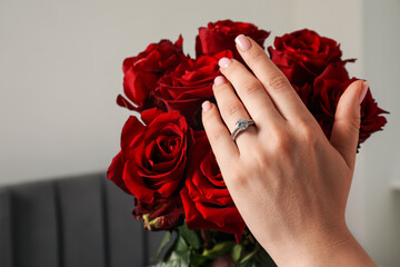Dreams come true. Happy woman with engagement ring and beautiful bouquet indoors, closeup