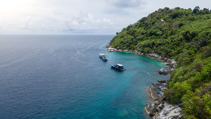 Group of recreational vessels or scuba diving boats anchoring over turquoise clear water at Racha Noi Island or Koh Racha Noi in Phuket, Thailand. Aerial view of a popular destination in Andaman sea