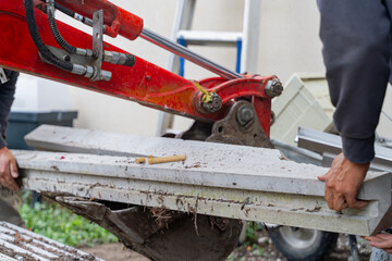 Manitou en action dans un jardin, d&eacute;barrassant des d&eacute;bris visibles dans le godet.