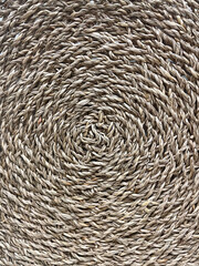 Close-up of a natural woven straw texture in circular pattern. Rustic eco-friendly handmade design, perfect for backgrounds, decoration, interior design, crafts, and organic lifestyle concepts.