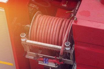 Close to the pipes and fire hoses, they are working together to put out the fire with water.