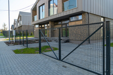 A modern townhouse with a private, fenced yard and a paved driveway