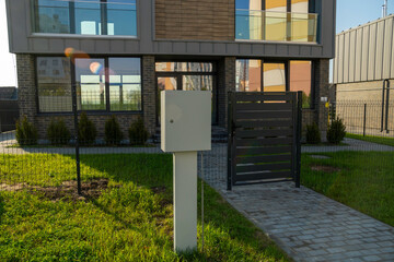 Electrical panel with meter installed on exterior wall of modern two-story townhouse
