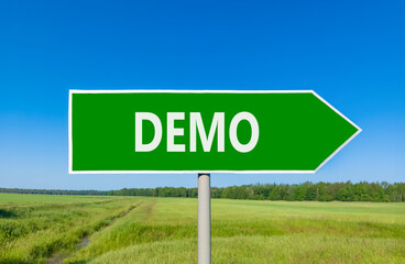 Demo symbol. Concept word Demo on beautiful green road sign. Beautiful blue sky green grass and...