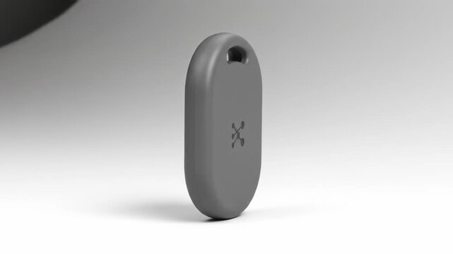 Gray oval-shaped key fob or tracker, side view